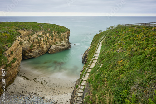 Moody long exposure of misty sea and rock at Praia das Catedrais, Beach of the Cathedrals in Ribadeo, Galicia Spain