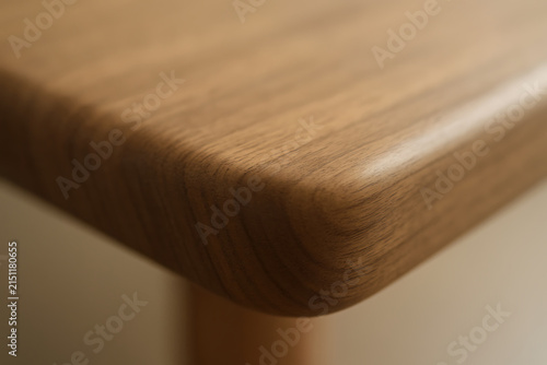 Close up of rounded wooden table edge with warm natural grain