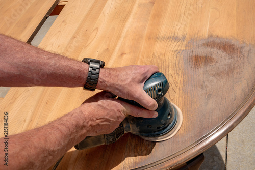 Fotografía Craftsman uses a palm sander to finish a tabletop