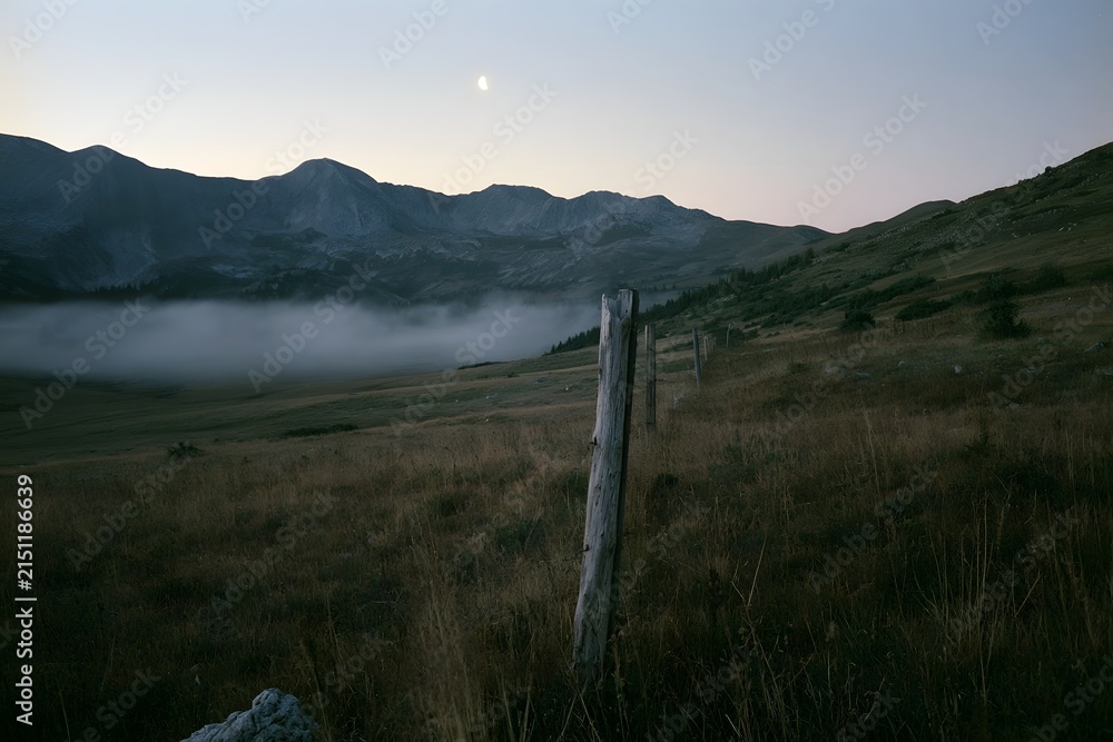Fototapeta premium Alpine tundra at twilight with ground fog and boundary post
