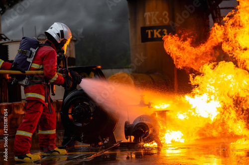 Photography Male firefighter in full protective gear and SCBA equipment work to extinguish d