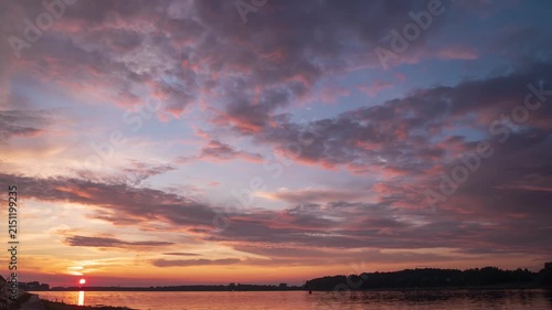 Scenic view of beautiful sunset or sunrise above the pond or lake at spring or early summer evening with cloudy sky background  Landscape. Water reflection. 