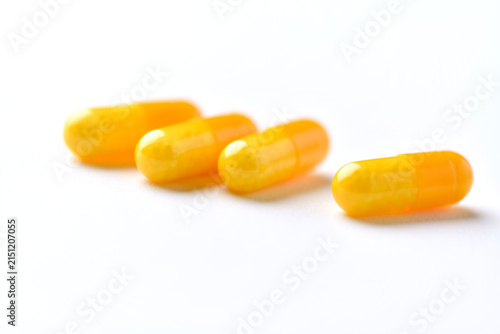 Vitamin C capsules. Antioxidants. Concept for a healthy dietary supplementation. Bright paper background. Soft focus. Close up. Copy space.