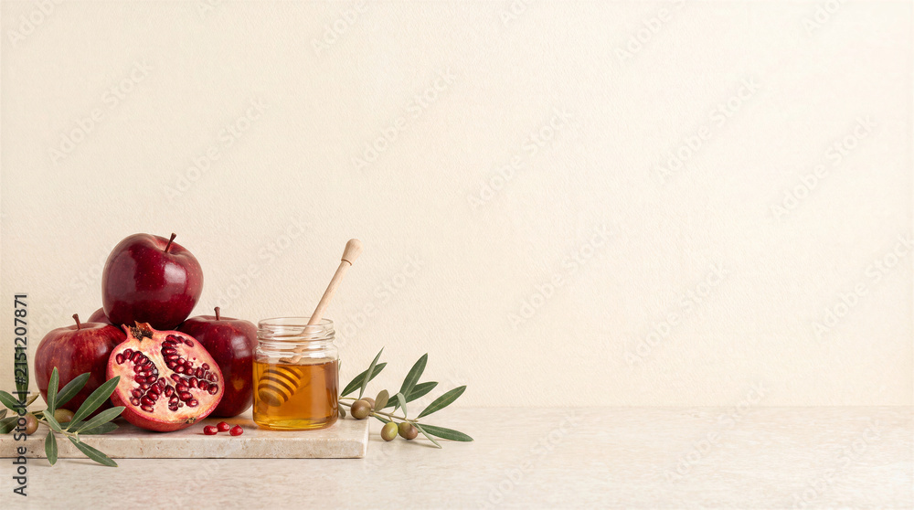 Fototapeta premium Rosh Hashanah Celebration Concept Traditional Jewish New Year Symbols Including Fresh Red Apples Pomegranate Honey Jar And Green Olive Branches On Minimalist Stone Surface, Fruit, Organic Food