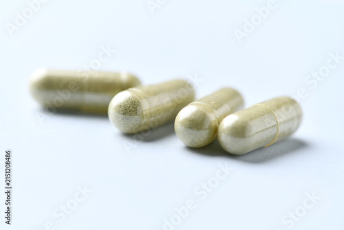 Barley grass capsules. Antioxidants. Concept for a healthy dietary supplementation. Bright background. Soft focus. Close up. Copy space.