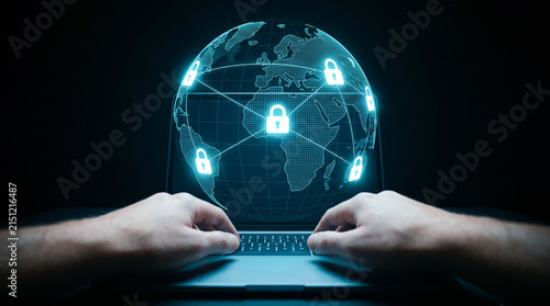 User typing on laptop with digital globe hologram and glowing padlock icons