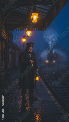 Halloween train conductor holds lantern at misty station platform