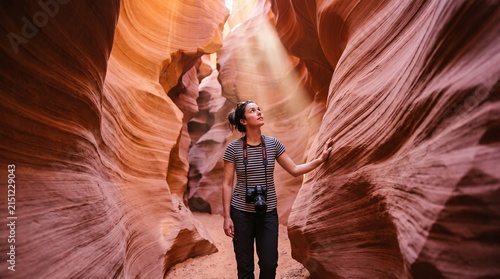 Woman Traveler Looking Up at Sunbeams Inside Antelope Slot Canyon