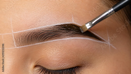 Brow henna application with angled brush on mapped eyebrow