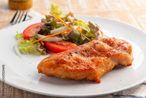 Grilled Black Pepper Chicken Breast with red oak lettuce ,tomatoes,carrot and onion in white plate.Healthy food diet.