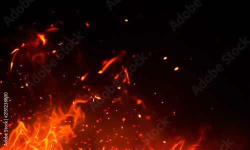 Fiery sparks and embers rising against a dark black background dramatic flame texture