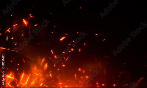 Fiery sparks rising from embers with a dark background dramatic firelight and glowing particles