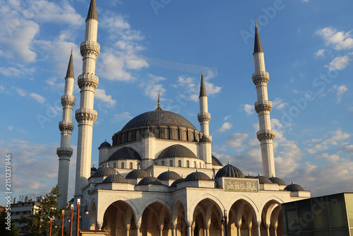 Fotografie Grand mosque with multiple minarets and domes under a blue sky