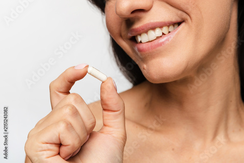 Young woman taking daily vitamin supplement for wellness
