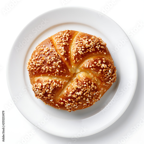 Sweet brioche bun sprinkled with sugar on a white plate isolated on white background