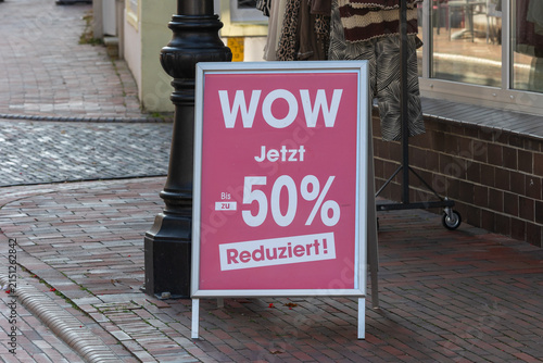 Pink sandwich board sign displaying 50 percent off sale