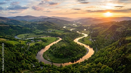 Breathtaking aerial view of a majestic winding river at sunset through a lush green valley.