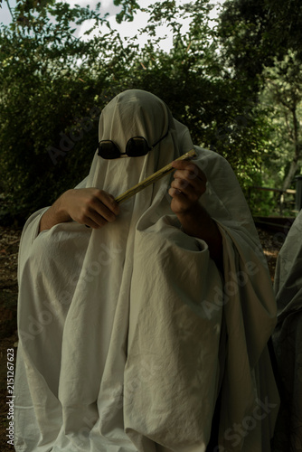 Person in Ghost Costume Holding Stick Outdoors