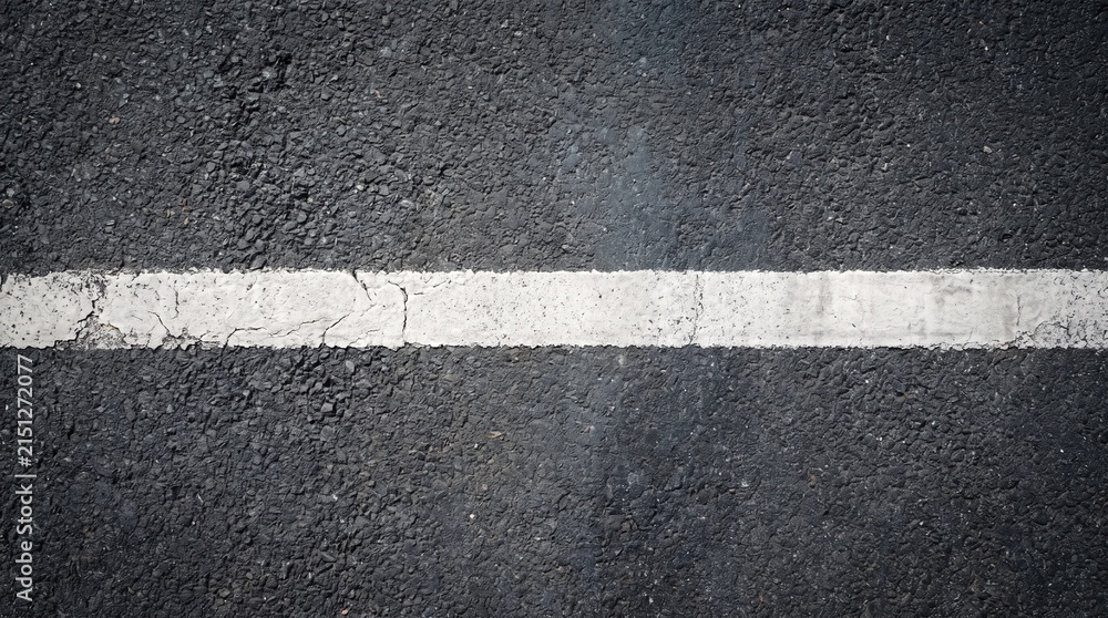 Fototapeta premium Top view of textured black asphalt road with a distressed white line marking