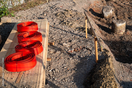 Red construction coils on wooden planks at building site