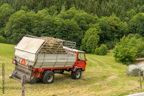 Gadmen, Switzerland. Agricultural utility vehicle transporting hay on an alpine meadow in the Swiss Alps