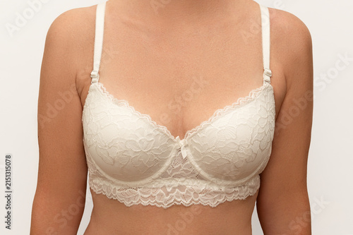 White lace bra on a woman's body on a white background.