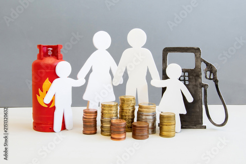 Принти на полотні A family stands between a gas pump and a gas tank, surrounded by stacks of coins