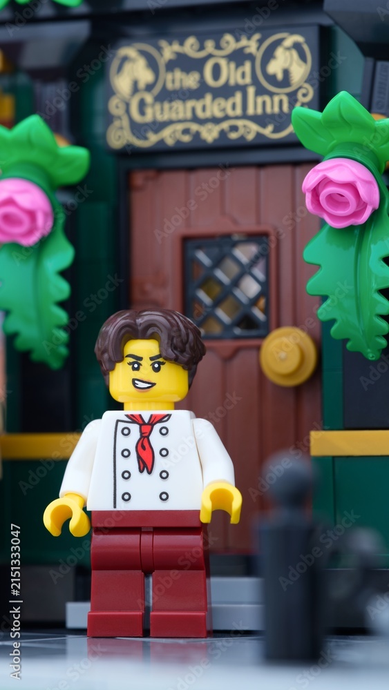 Fototapeta premium Tambov, Russian Federation - June 24, 2025 A close-up shot of a Lego innkeeper minifigure with a smirk standing outside 