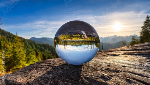 a serene glass sphere reflecting vibrant landscapes capturing the essence of nature with stunning clarity and depth