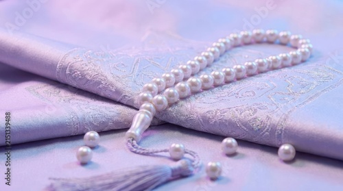 White prayer beads on purple silk with pearls.