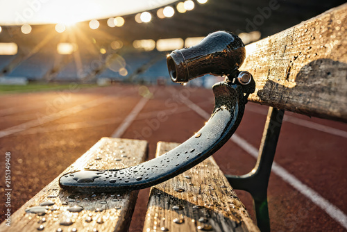 Carbon fiber running blade prosthetic resting on a wet stadium bench