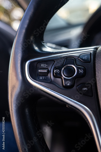 Foto Close up view of multifunctional buttons on black leather car steering wheel