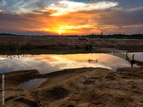 Fotografie A low autumn sun dips below the horizon, painting the crisp sky in fiery orange and soft violet