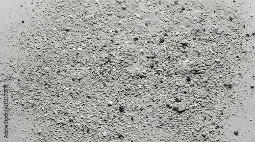 Small pile of gray gravel and crushed stones on a flat textured ground surface