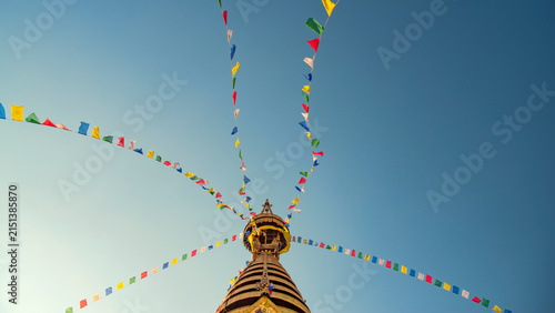 Foto Buddhist prayer flags radiating from Swayambhunath stupa spire with sky copy spa