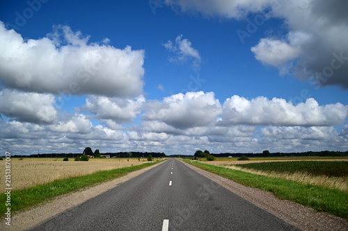 road in the field with clouds
