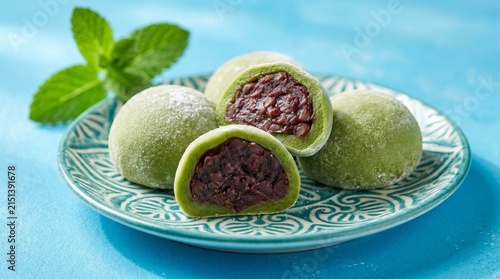 Delightful green matcha mochi and red bean paste served with fresh mint garnish.