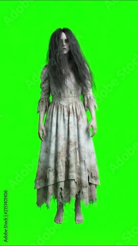 Zombie woman in tattered white dress standing still on green screen background