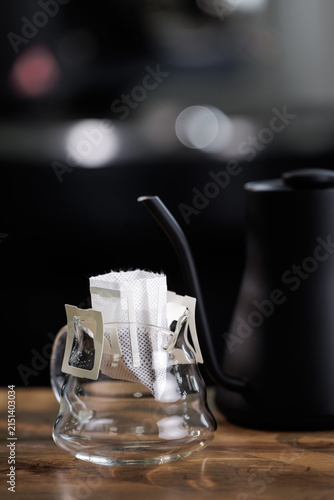 Fotografie Drip coffee closeup with disposable pour over bag perched in glass server