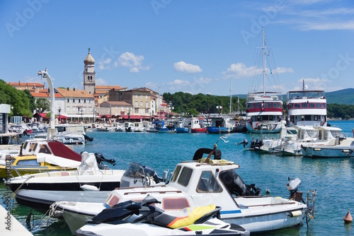 Sunny View of Punat Harbor with Boats and Church Tower