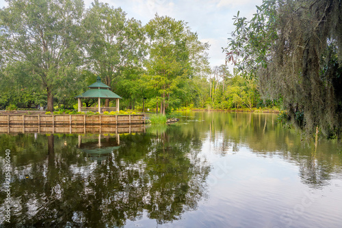 Obraz na plátne A gazebo along a pedestrian path surrounded by trees with Spanish Moss along the Waccamaw River at Riverfront Park, in Conway, South Carolina