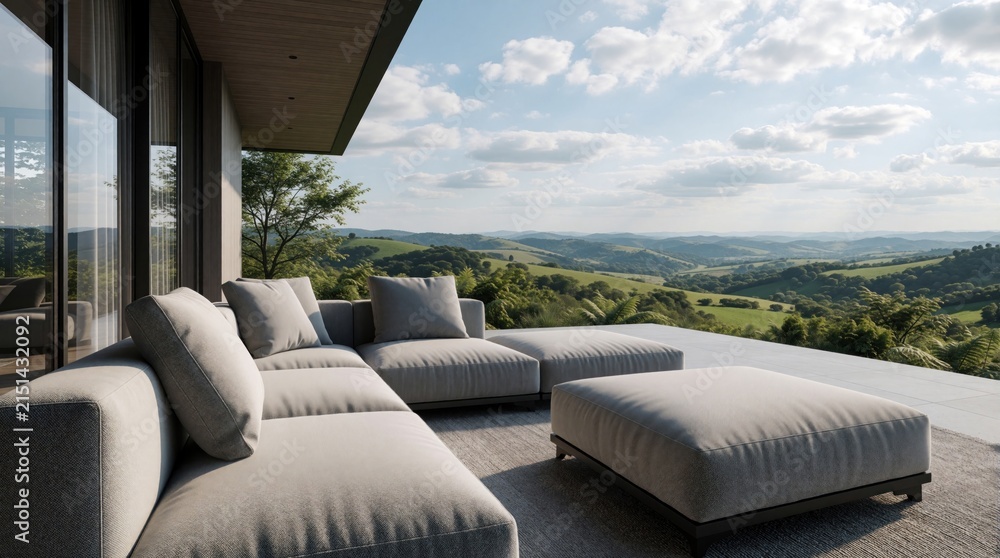 Obraz premium Modern outdoor lounge terrace features grey sofas with comfortable pillows on stone floor. Exterior deck area overlooks beautiful green hills, summer mountain landscape. Luxury real estate patio