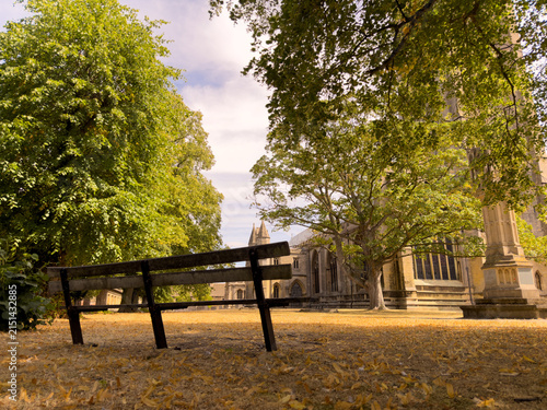 Bild auf Leinwand bench in the church yard with dry grass