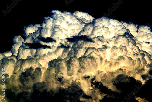 Obraz na płótnie A towering cumulonimbus cloud dominates the deep blue sky