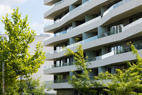 Photography Modern residential building with curved balconies and glass railings surrounded