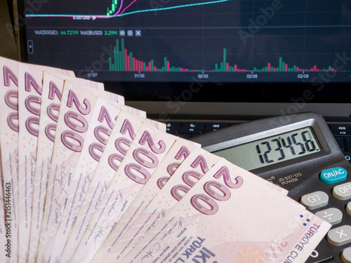 Turkish Lira Banknotes with Calculator and Stock Market Chart on Screen