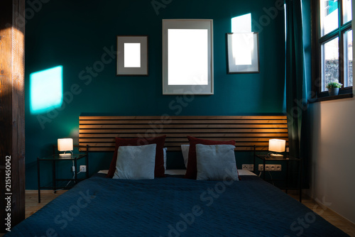 Konstfotografi Three blank frames above bed in dark teal bedroom