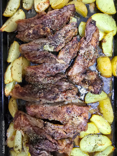 Roasted meat strips with seasoned baked potato wedges