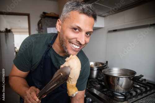Man Smiling Widely While Cooking Traditional Soup