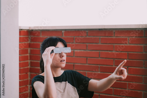 Una mujer sujeta unas gafas negras para ver un eclipse. Protección solar para la observación segura de un eclipse total. Accesorio para observar el eclipse 